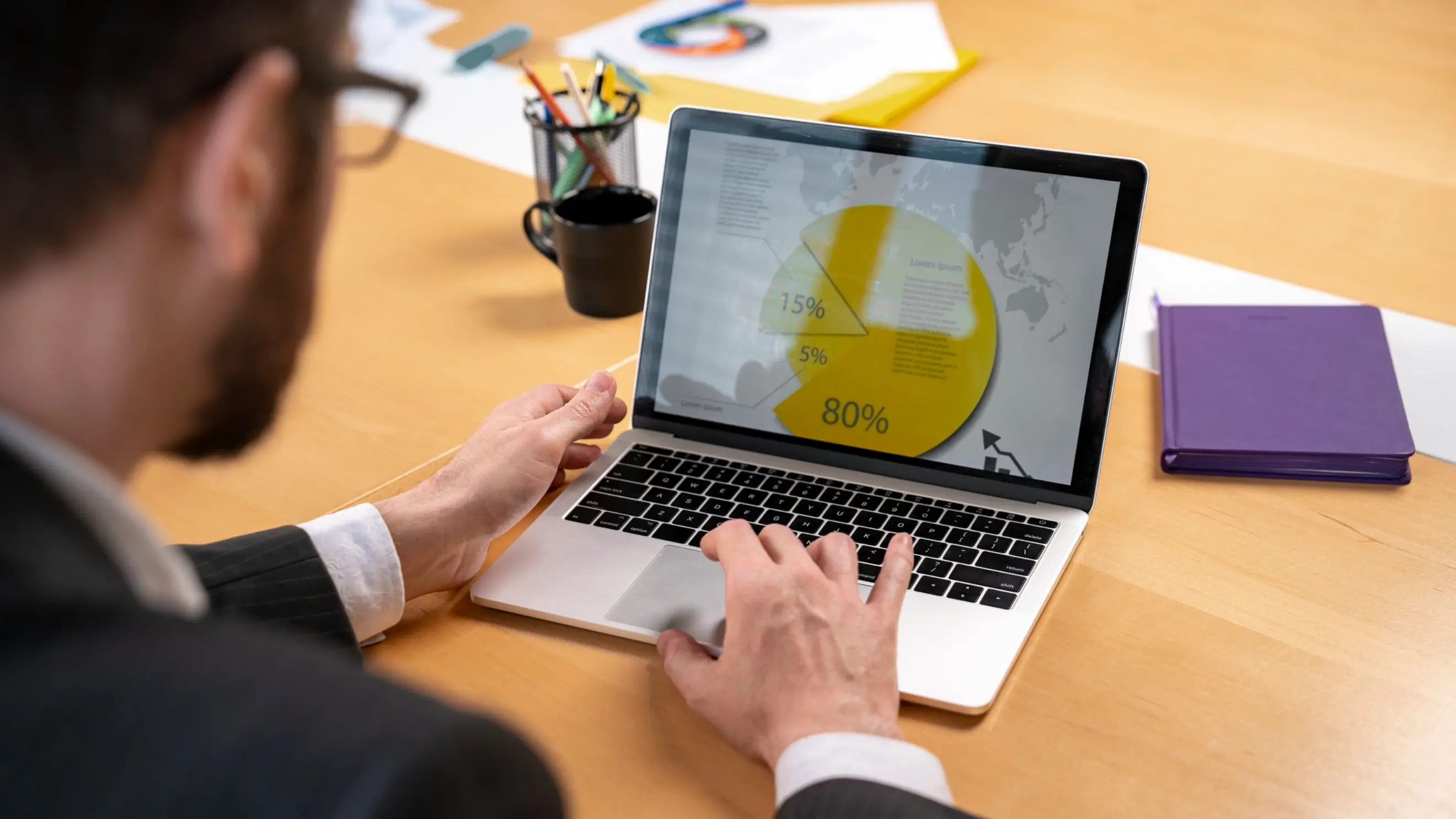 A business professional analyzing PPC advertising campaign data and performance charts on a laptop screen.